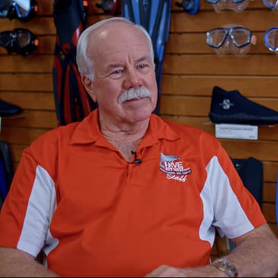 a man with grey hair in an orange shirt